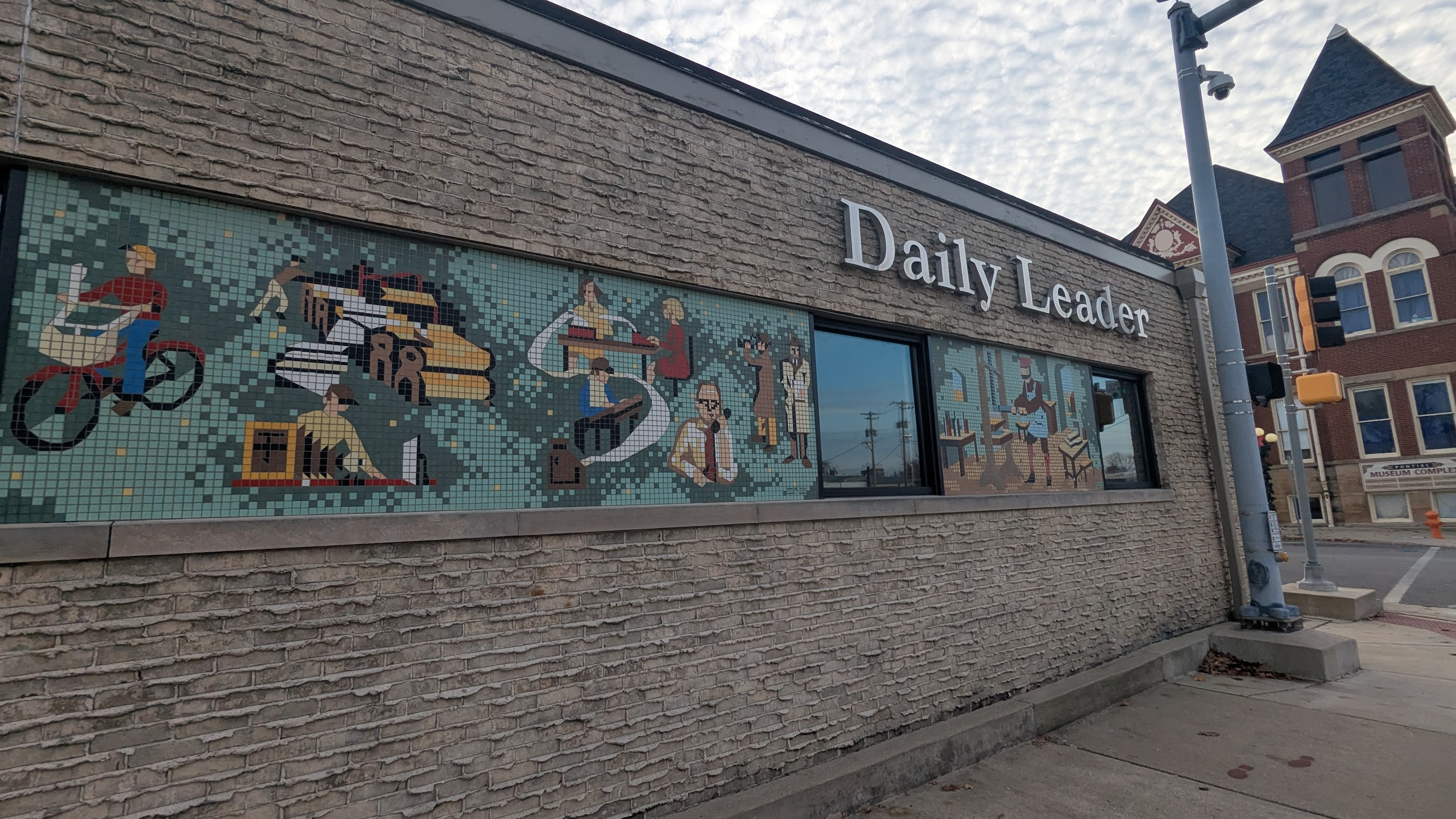 the Daily Leader building in Pontiac illinois, a one-story brick building with two mosaics on this side of it.