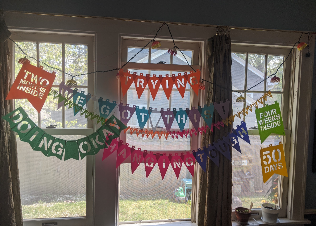 Colorful banners with motivational phrases and a countdown of days decorate a window.