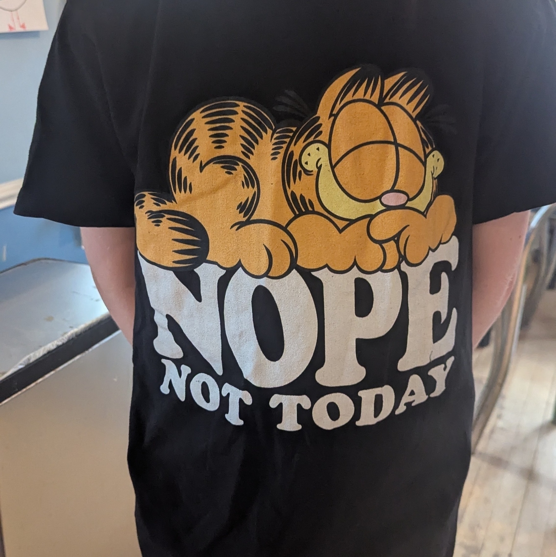 A black T-shirt with Garfield on it and the words "nope not today"