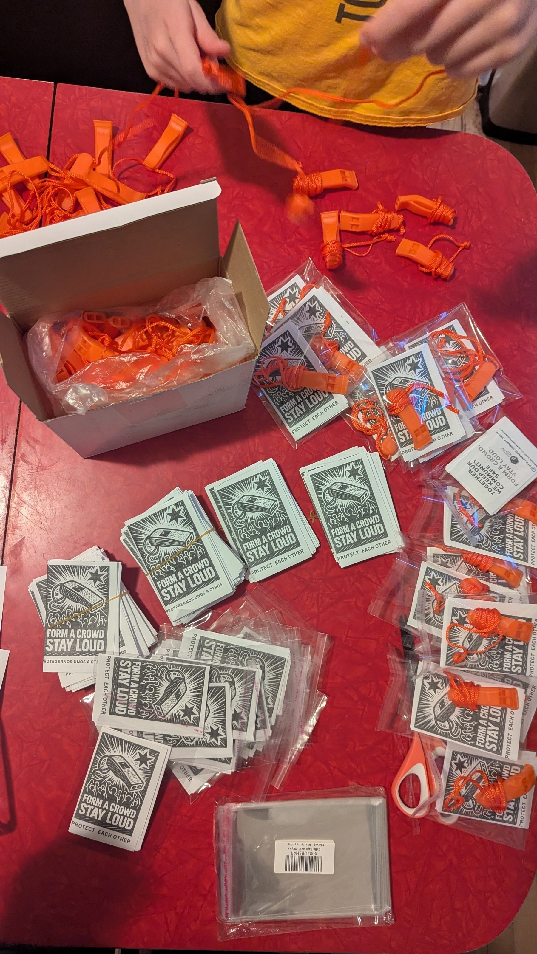 Assembling ICE whistle packs on a red table