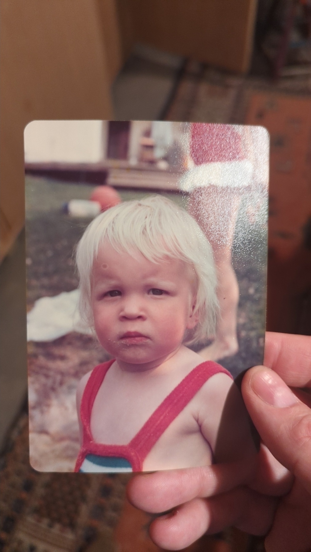 A young child with blond hair is staring directly at the camera