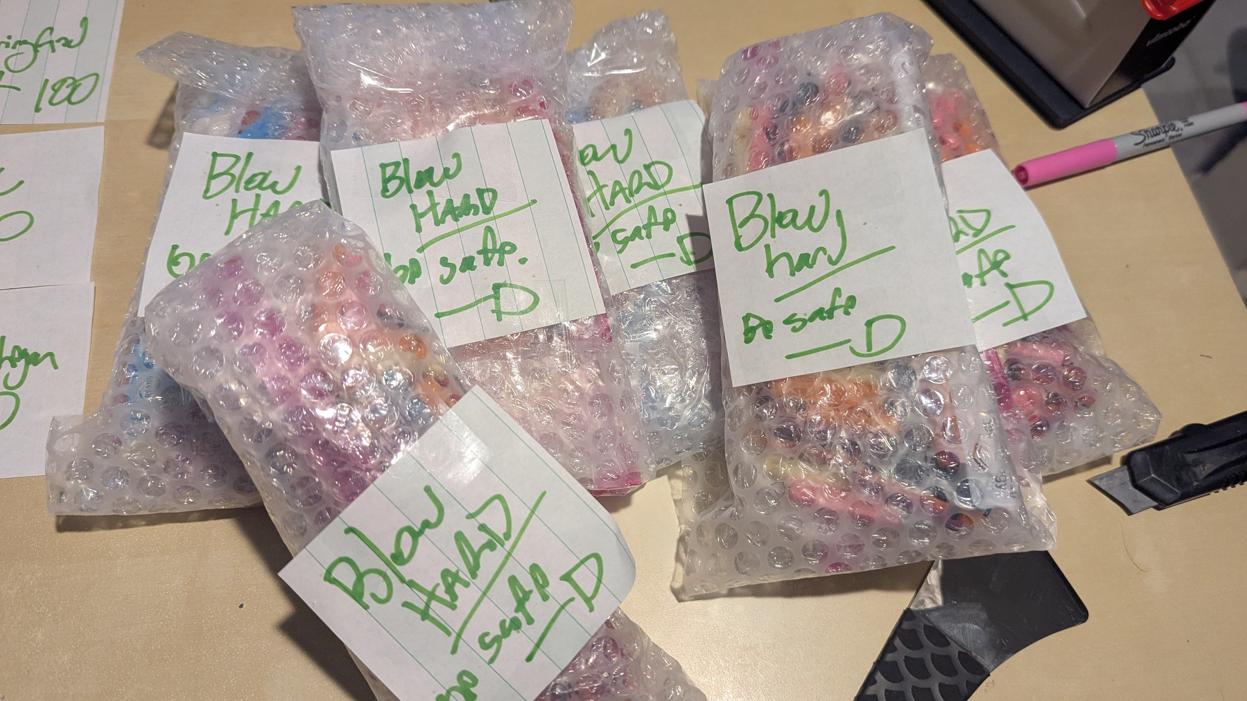 Six bundles of whistles packed with notes that say "blow hard, be safe"