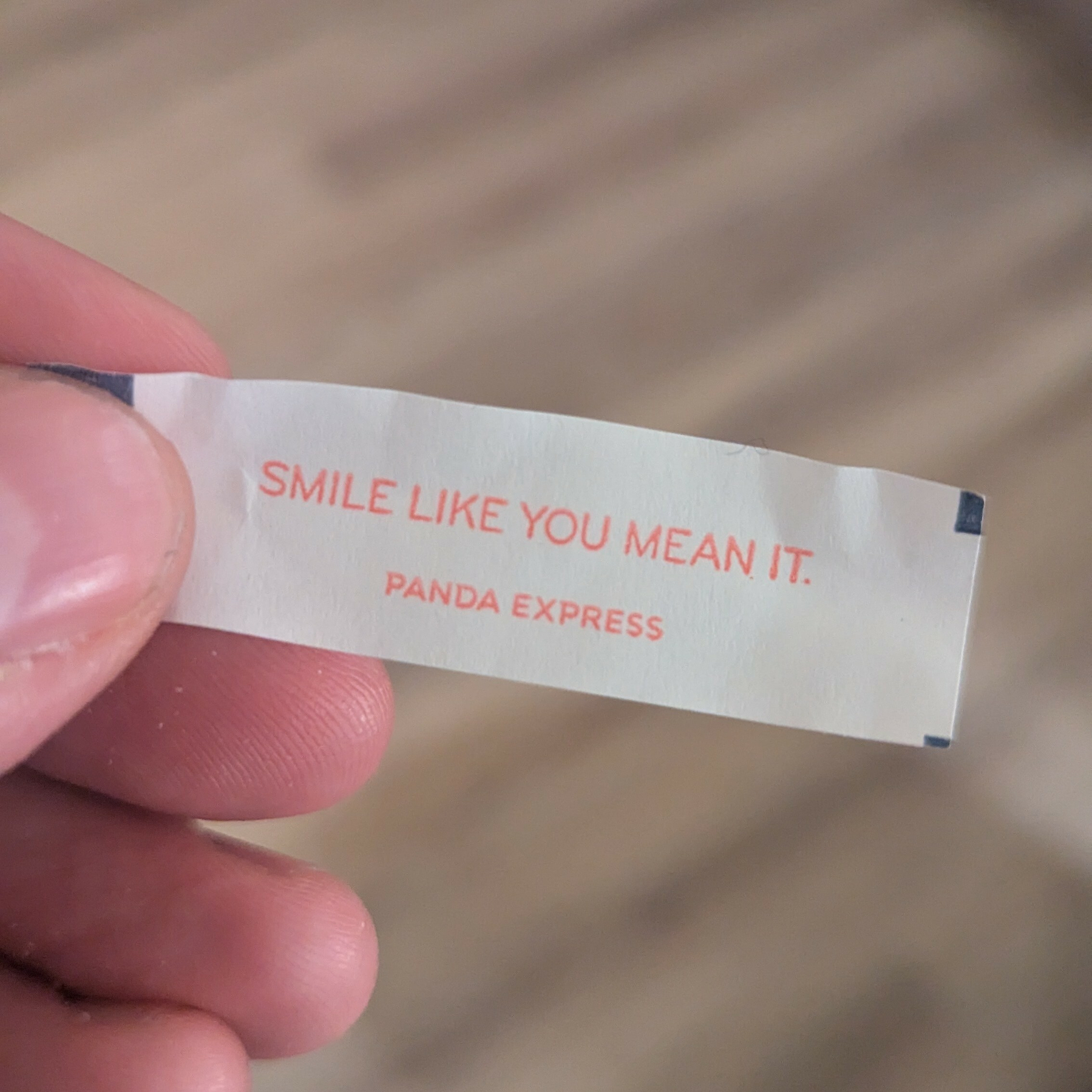A fortune with the message SMILE LIKE YOU MEAN IT on it.